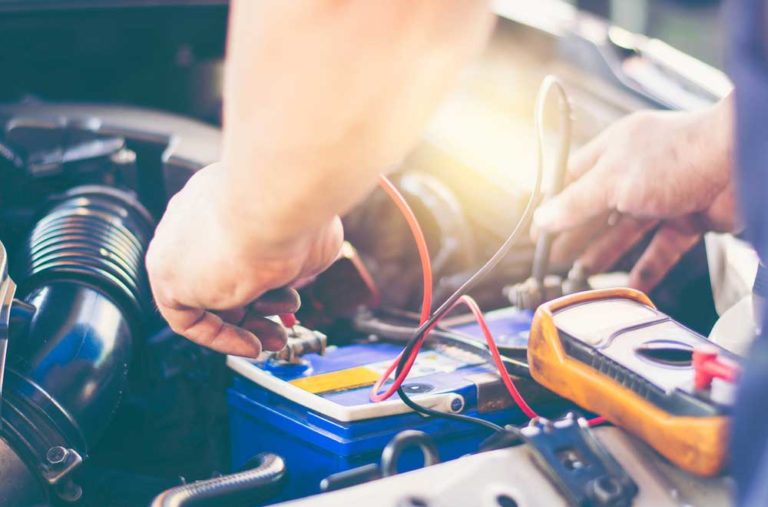 Mechanic Uses A Multimeter To Check The Voltage Level Of A Car Battery