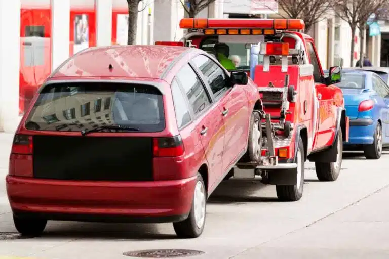 Tow Truck Lifting A Red Car