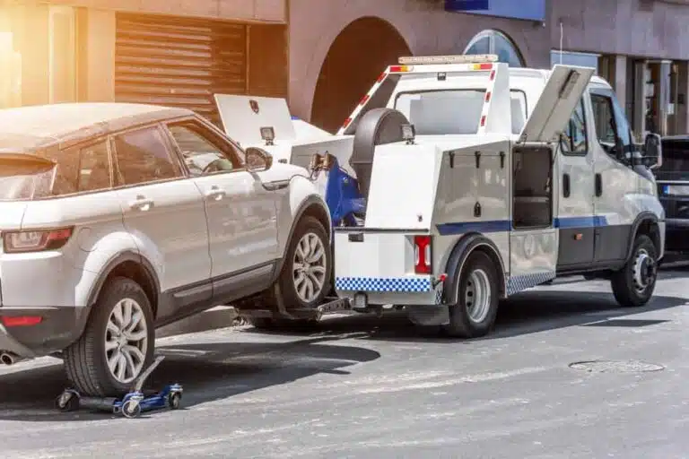 Truck Towing A Broken Car On The Road